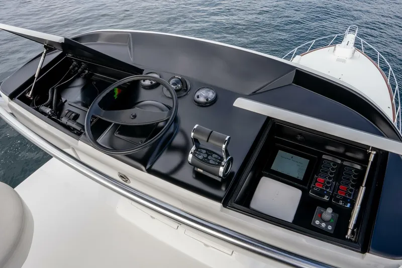 Slide: The Image of Control panel of 2018 Viking 80 Enclosed Bridge yacht, featuring steering wheel and navigation instruments. - 62
