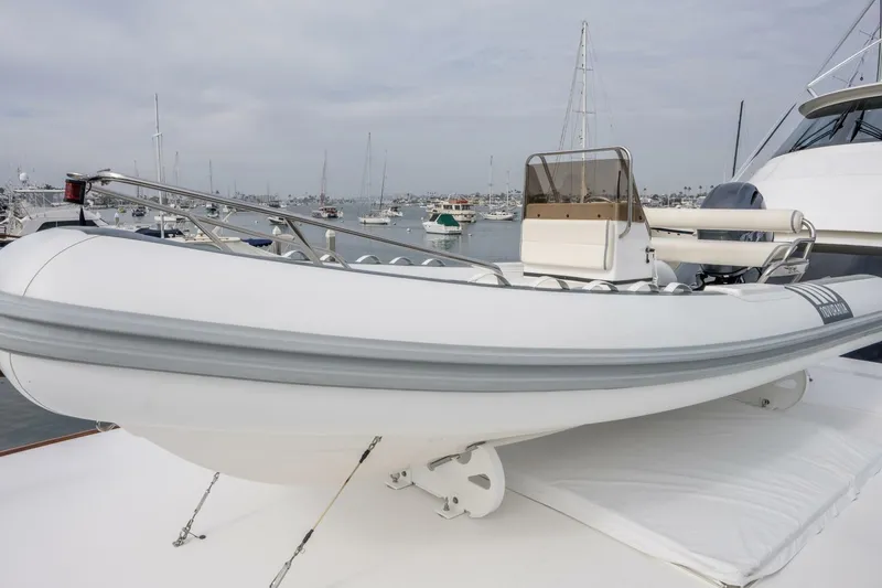 Slide: The Image of White inflatable boat on a 2018 Viking 80 Enclosed Bridge yacht, docked in a marina. - 66