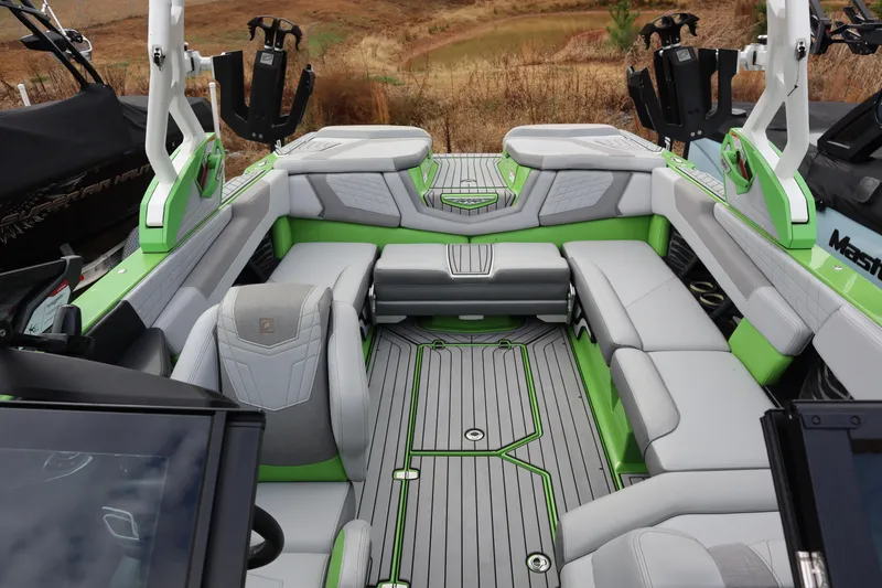 Slide: The Image of 2021 Nautique Super Air Nautique G23 interior with green and gray seating, luxury design. - 10