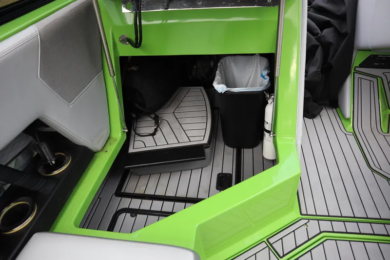 Slide: The Image of Interior of 2021 Nautique Super Air Nautique G23 with green accents and storage area. - 17