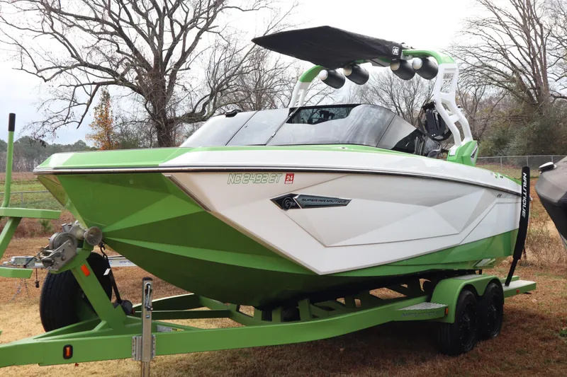 Slide: The Image of 2021 Nautique Super Air Nautique G23 boat in green and white on trailer. - 2