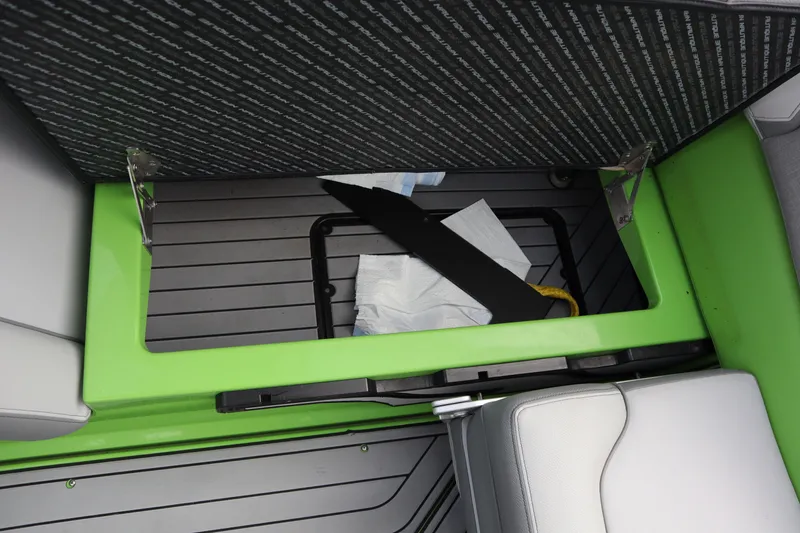 Slide: The Image of 2021 Nautique Super Air Nautique G23 storage compartment with green trim and accessories. - 22