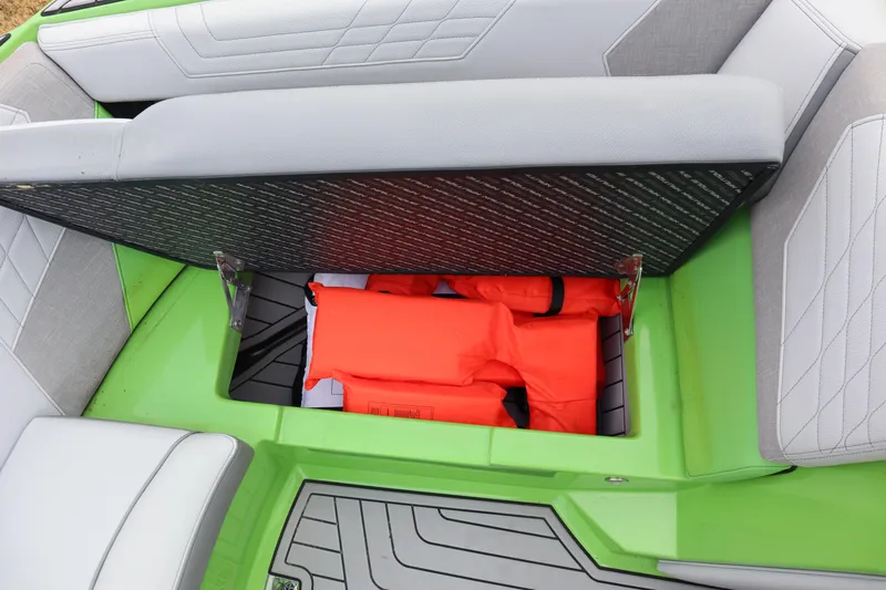 Slide: The Image of 2021 Nautique Super Air Nautique G23 storage compartment with orange life jackets. - 9