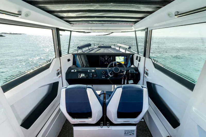 Slide: The Image of Interior view of 2026 Axopar 29 XC Aft Sofa, featuring modern helm and ocean backdrop. - 9