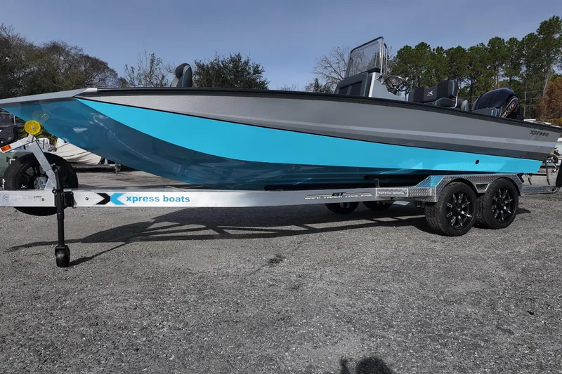 Slide: The Image of 2026 Xpress X23B Bay Lounge boat on trailer, featuring sleek blue and gray design. - 3