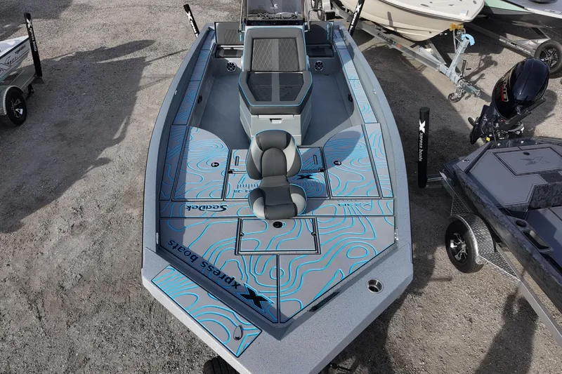 Slide: The Image of 2026 Xpress X23B Bay Lounge boat with modern design and seating, displayed outdoors. - 8