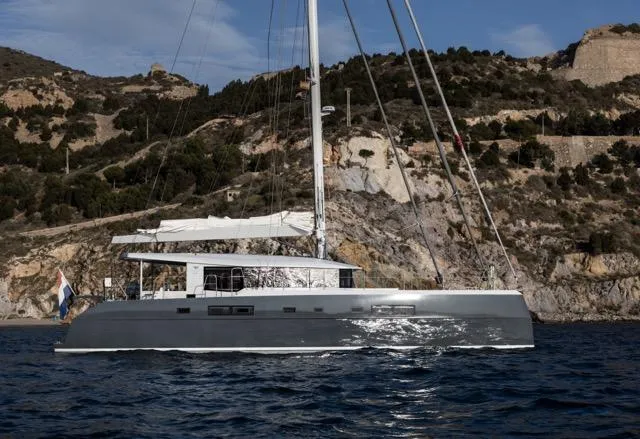 Slide: The Image of Sleek Eyecat 55 Autumn 2024 yacht sailing near rocky coastline under clear skies. - 10