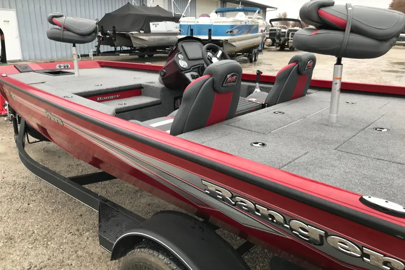 Slide: The Image of 2025 Ranger RT178 boat, red exterior, spacious interior, parked outdoors. - 2