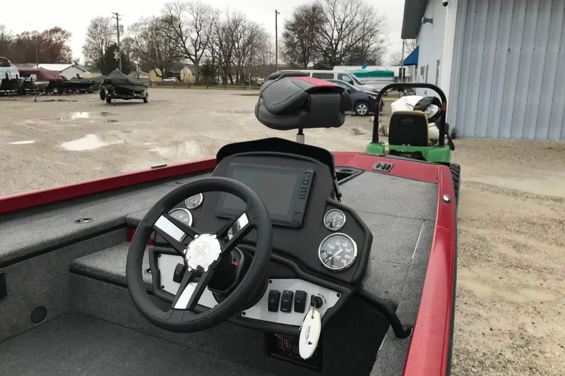 Slide: The Image of 2025 Ranger RT178 boat dashboard with steering wheel and gauges in a parking area. - 3