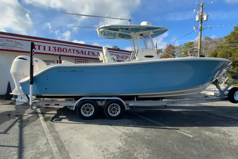 The Image of 2022 Cobia 280 Center Console boat on trailer at dealership. - 1