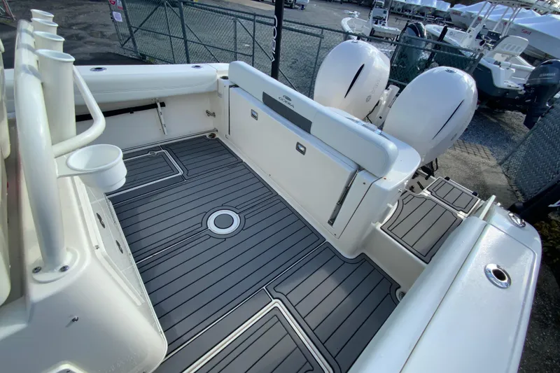 Slide: The Image of 2022 Cobia 280 Center Console boat deck with twin engines and rod holders. - 14