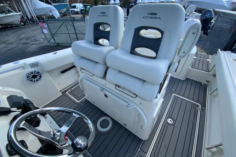 Slide: The Image of 2022 Cobia 280 Center Console boat interior with dual seats and steering wheel. - 18