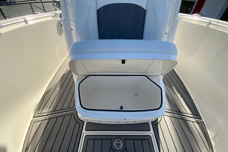 Slide: The Image of 2022 Cobia 280 Center Console boat with open storage compartment on deck. - 24