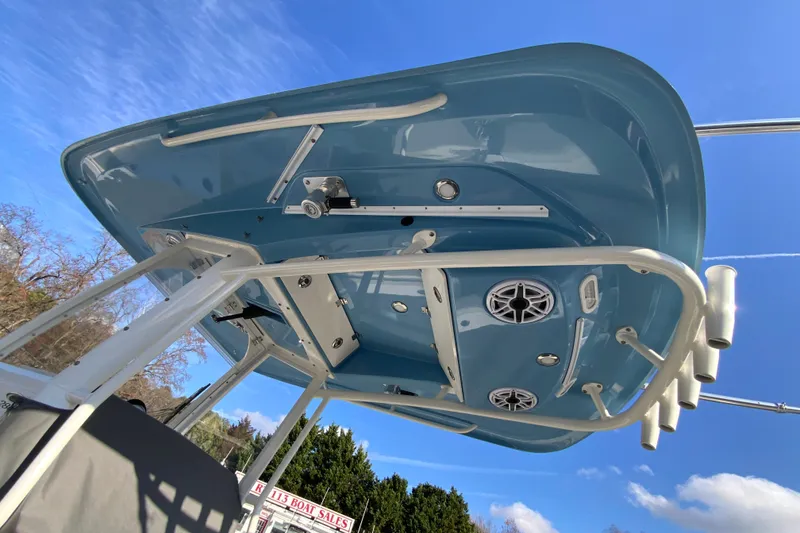 Slide: The Image of 2022 Cobia 280 Center Console boat's blue T-top with speakers and rod holders. - 33