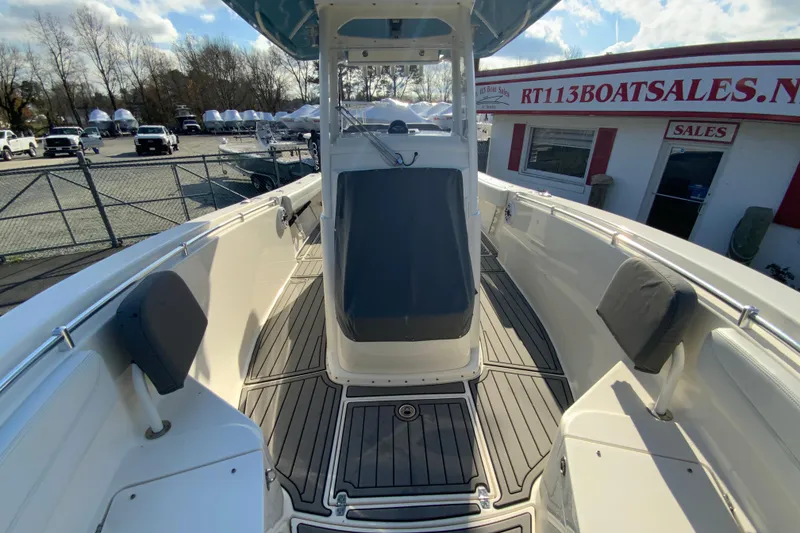 Slide: The Image of 2022 Cobia 280 Center Console boat at dealership, showcasing spacious deck and seating. - 34