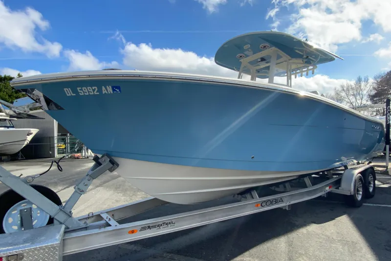 Slide: The Image of 2022 Cobia 280 Center Console boat on trailer under blue sky. - 5