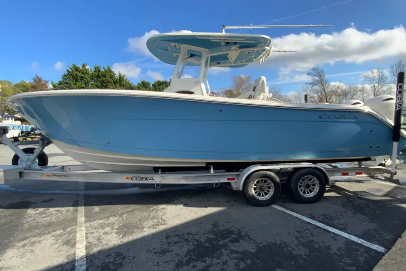 Slide: The Image of 2022 Cobia 280 Center Console boat on trailer, blue hull, parked outdoors. - 6