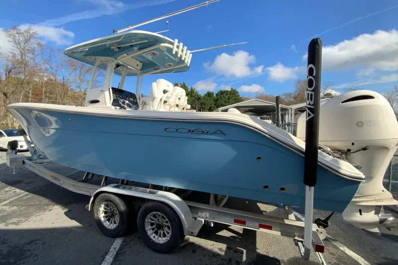 Slide: The Image of 2022 Cobia 280 Center Console boat on trailer, blue hull, outdoor setting. - 7