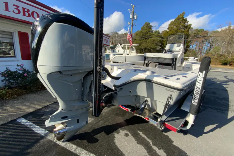 Slide: The Image of 2023 Pathfinder 2300 HPS boat with powerful outboard motor in a sunny outdoor setting. - 10