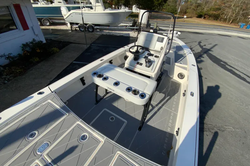 Slide: The Image of 2023 Pathfinder 2300 HPS boat interior with console and seating, docked outdoors. - 11