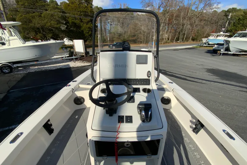 Slide: The Image of 2023 Pathfinder 2300 HPS boat console with steering wheel and controls, parked outdoors. - 12