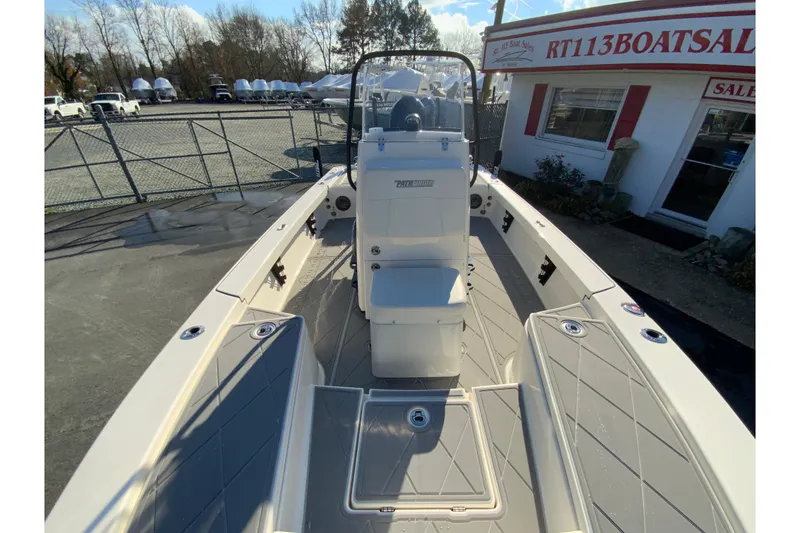 Slide: The Image of 2023 Pathfinder 2300 HPS boat at dealership, showcasing spacious deck and seating. - 28