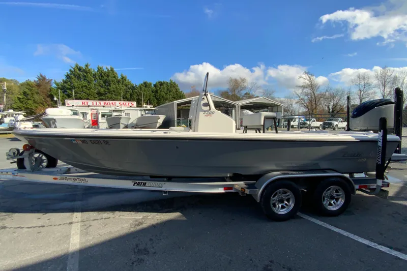 Slide: The Image of 2023 Pathfinder 2300 HPS boat on trailer at dealership, clear sky background. - 6