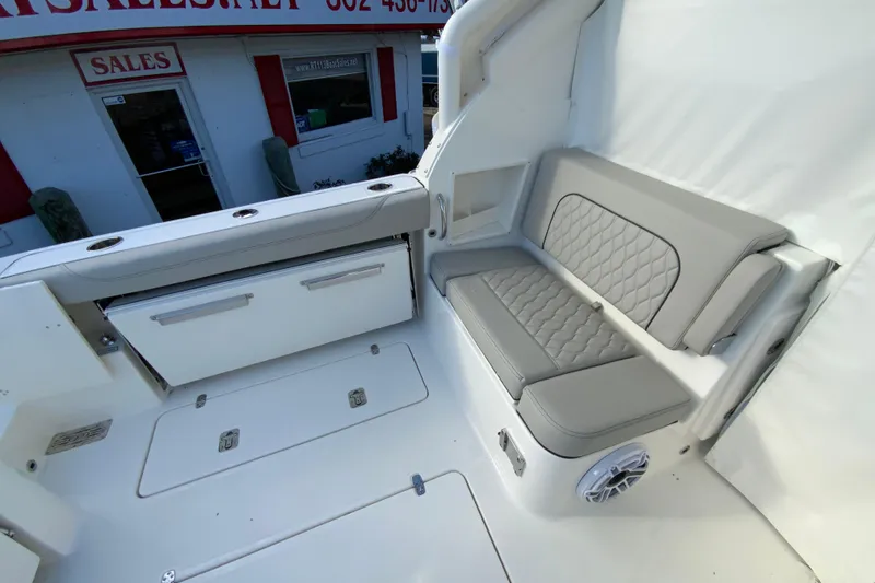 Slide: The Image of 2026 Pursuit DC 326 Dual Console boat interior with cushioned seating and storage compartments. - 13