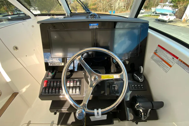 Slide: The Image of 2026 Pursuit DC 326 Dual Console helm with steering wheel and control panel. - 21