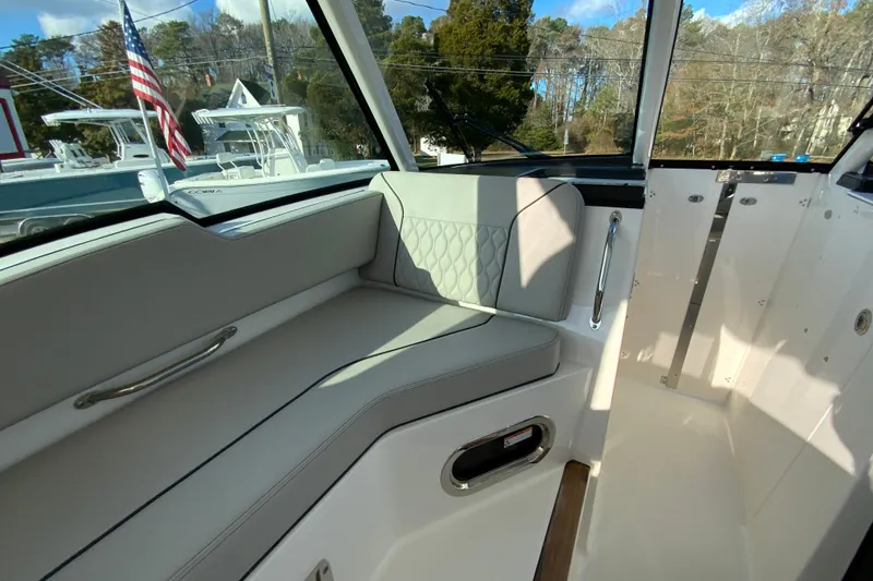 Slide: The Image of 2026 Pursuit DC 326 Dual Console interior with cushioned seating and sleek design. - 29