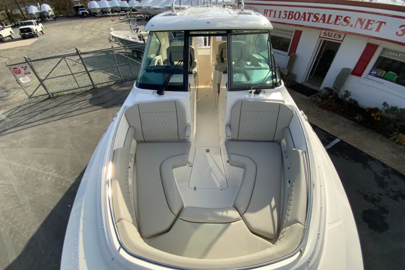 Slide: The Image of 2026 Pursuit DC 326 Dual Console boat with spacious seating, docked at a sales location. - 36