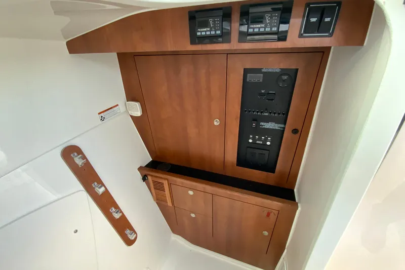 Slide: The Image of 2026 Pursuit DC 326 Dual Console interior control panel with wood finish. - 44