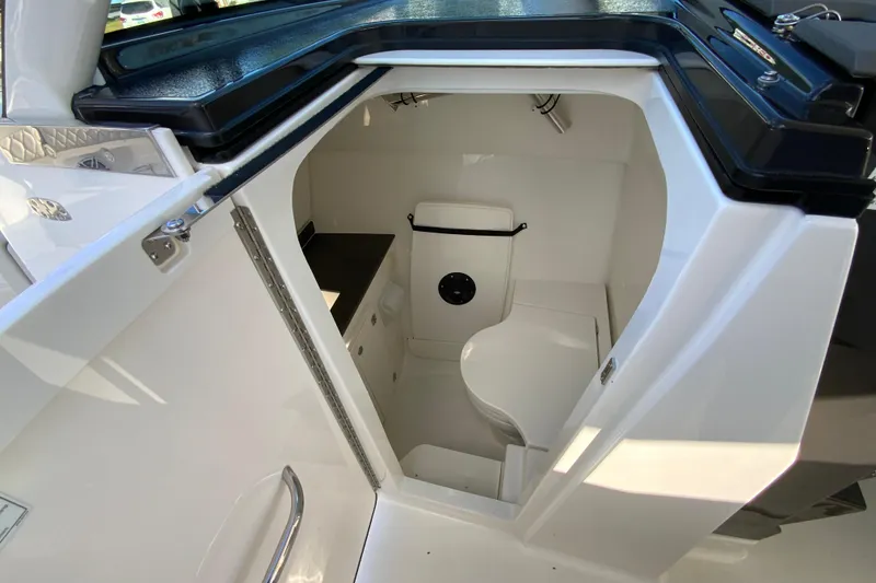 Slide: The Image of 2026 Pursuit DC 326 Dual Console boat interior with compact bathroom. - 49