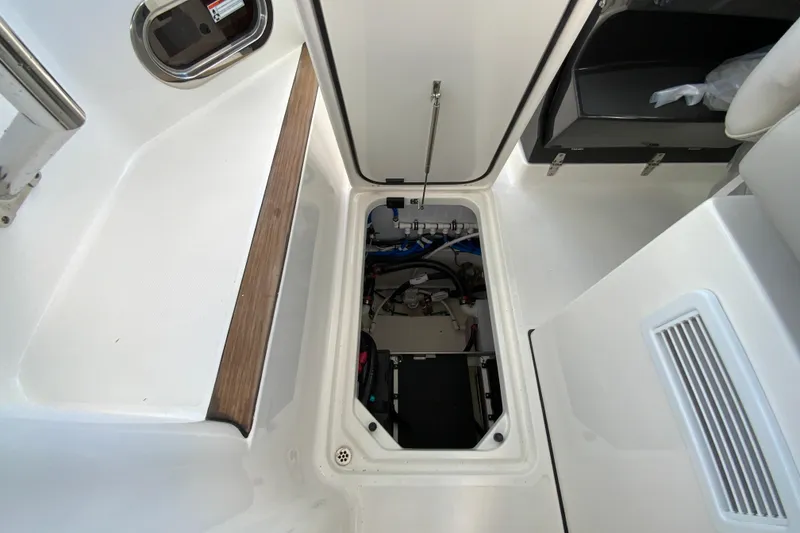 Slide: The Image of 2026 Pursuit DC 326 Dual Console boat interior with open storage compartment. - 52