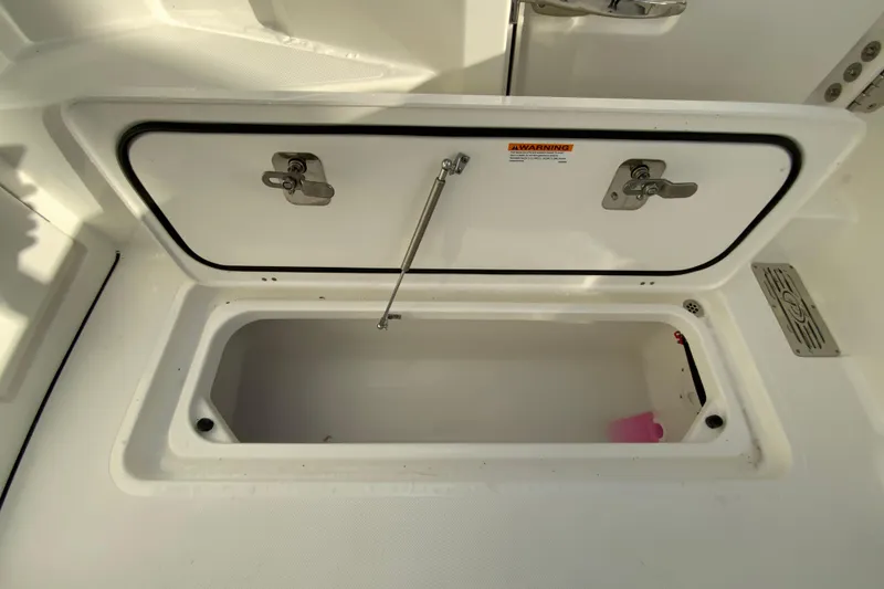 Slide: The Image of Open storage compartment on 2026 Pursuit DC 326 Dual Console boat. - 56