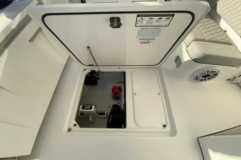 Slide: The Image of 2026 Pursuit DC 326 Dual Console boat storage compartment with fire extinguisher and equipment. - 57
