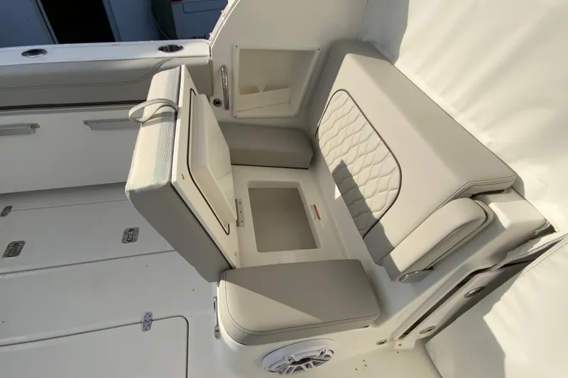 Slide: The Image of 2026 Pursuit DC 326 Dual Console boat interior with cushioned seating and storage compartments. - 60