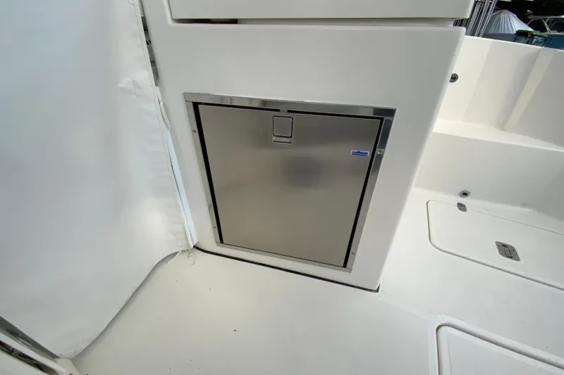Slide: The Image of Stainless steel compartment on 2026 Pursuit DC 326 Dual Console boat interior. - 63