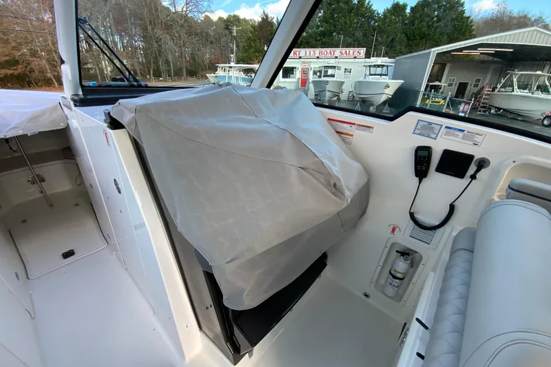 Slide: The Image of 2026 Pursuit DC 326 Dual Console interior with covered helm and control panel. - 66