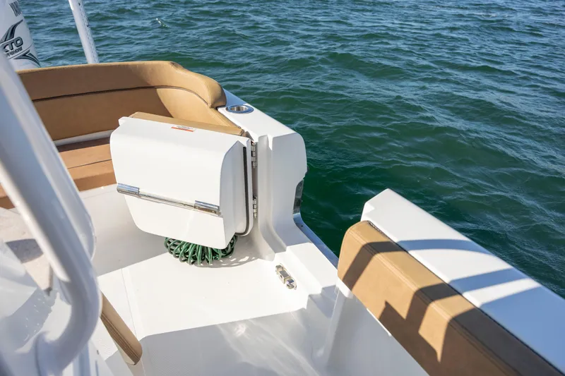 Slide: The Image of 2021 Sea Hunt Escape 27 boat interior with tan seating, near water. - 13