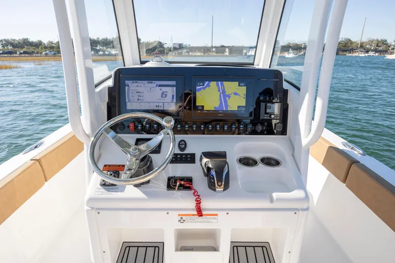 Slide: The Image of 2021 Sea Hunt Escape 27 boat dashboard with navigation screens and steering wheel. - 15