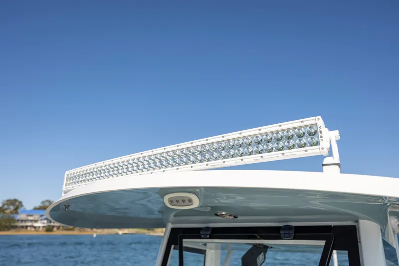 Slide: The Image of 2021 Sea Hunt Escape 27 boat with LED light bar on roof, clear blue sky. - 21