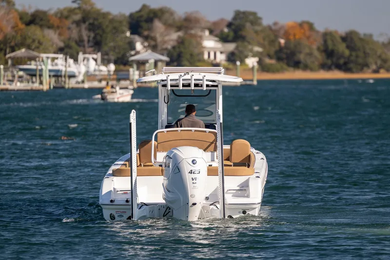 Slide: The Image of 2021 Sea Hunt Escape 27 boat cruising on a scenic lake with trees in the background. - 3