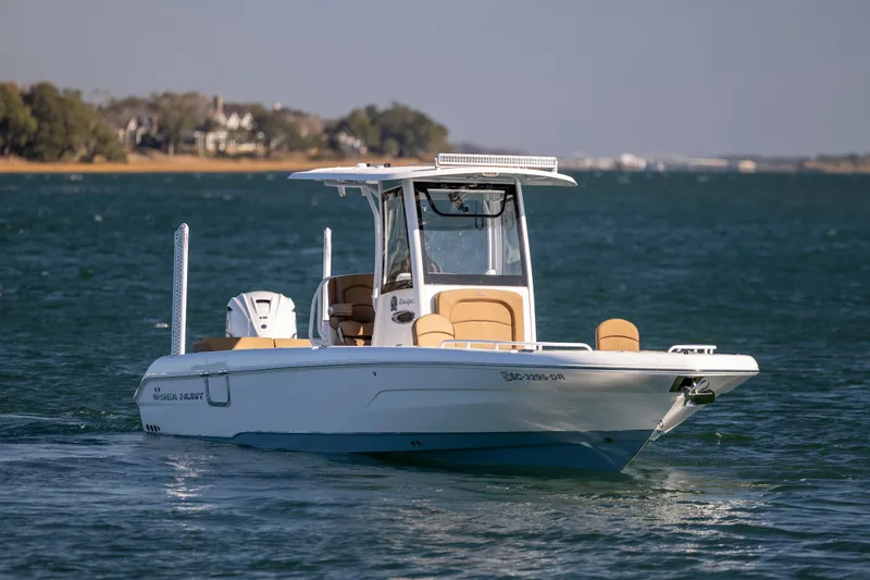 Slide: The Image of 2021 Sea Hunt Escape 27 boat cruising on a calm lake with scenic background. - 5