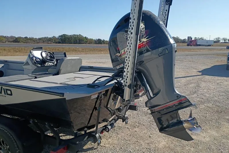 Slide: The Image of 2025 Avid 20 Rogue SC boat with powerful outboard motor in a parking area. - 6