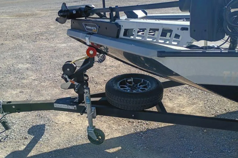 Slide: The Image of Trailer hitch of 2025 Avid 20 Rogue SC boat with spare tire on gravel. - 8