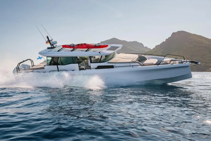 The Image of 2026 Axopar 45 XC AC Brabus Med Lithium cruising on water near mountains. - 0