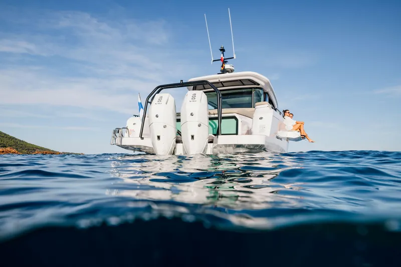 Slide: The Image of 2026 Axopar 45 XC AC Sandstone Lithium boat on open water, rear view. - 4