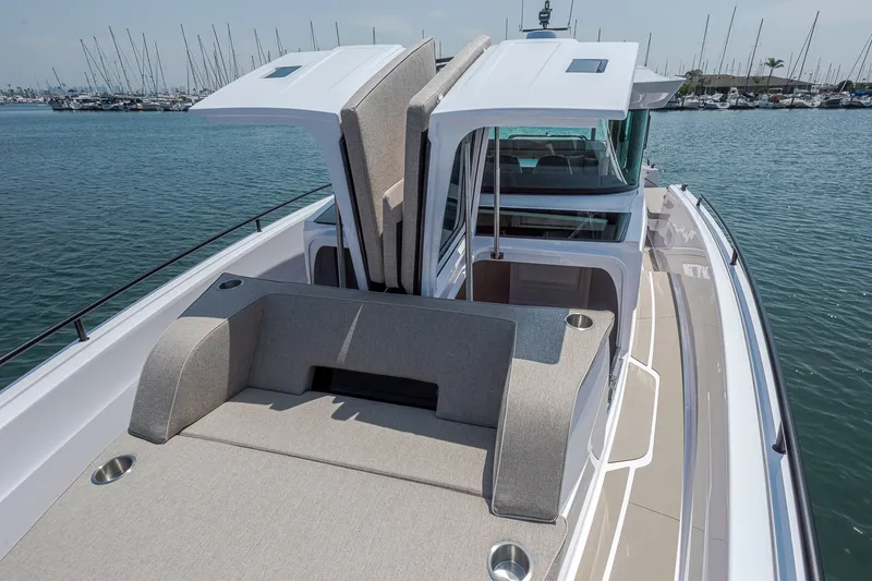Slide: The Image of 2026 Axopar 45 XC Cross Cabin boat with open sunroof, docked in a marina. - 14