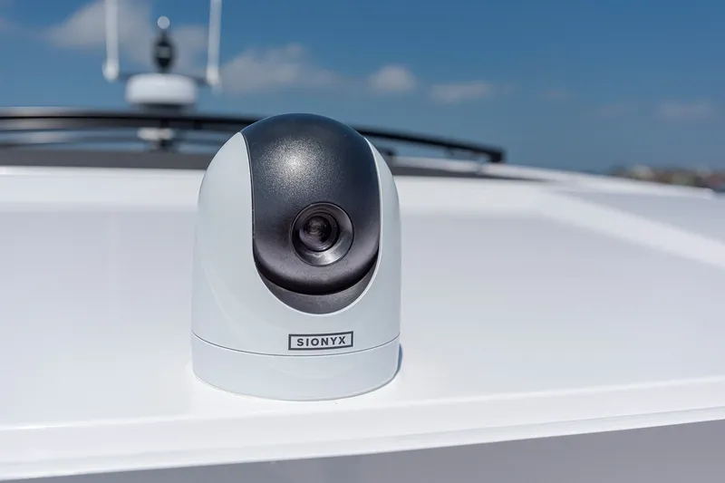 Slide: The Image of SIONYX camera on 2026 Axopar 45 XC Cross Cabin boat under clear blue sky. - 11